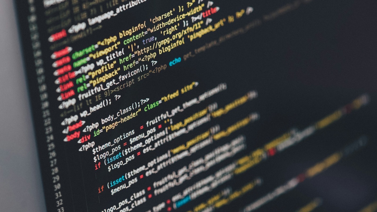 Tela de computador com linhas de código coloridas em fundo escuro